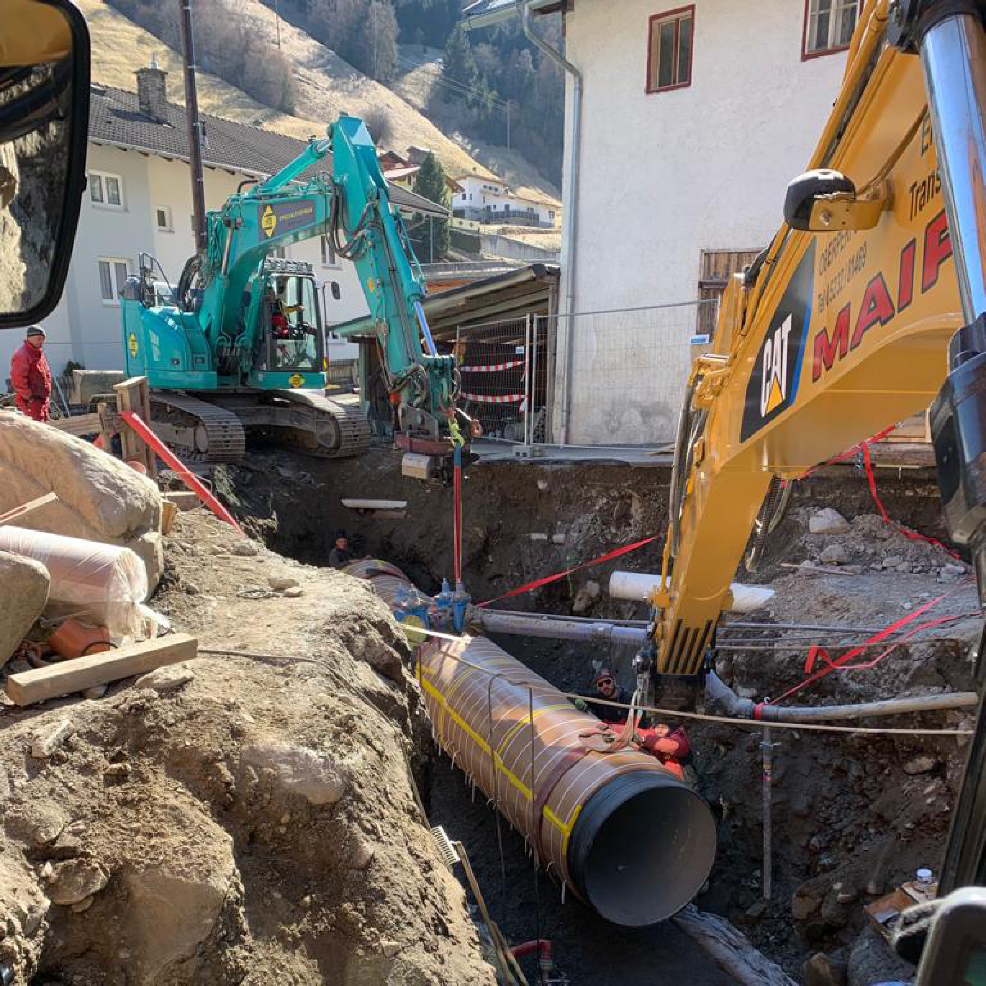 Zwei Kettenbagger und Bauarbeiter im Einsatz beim Leitungsbau