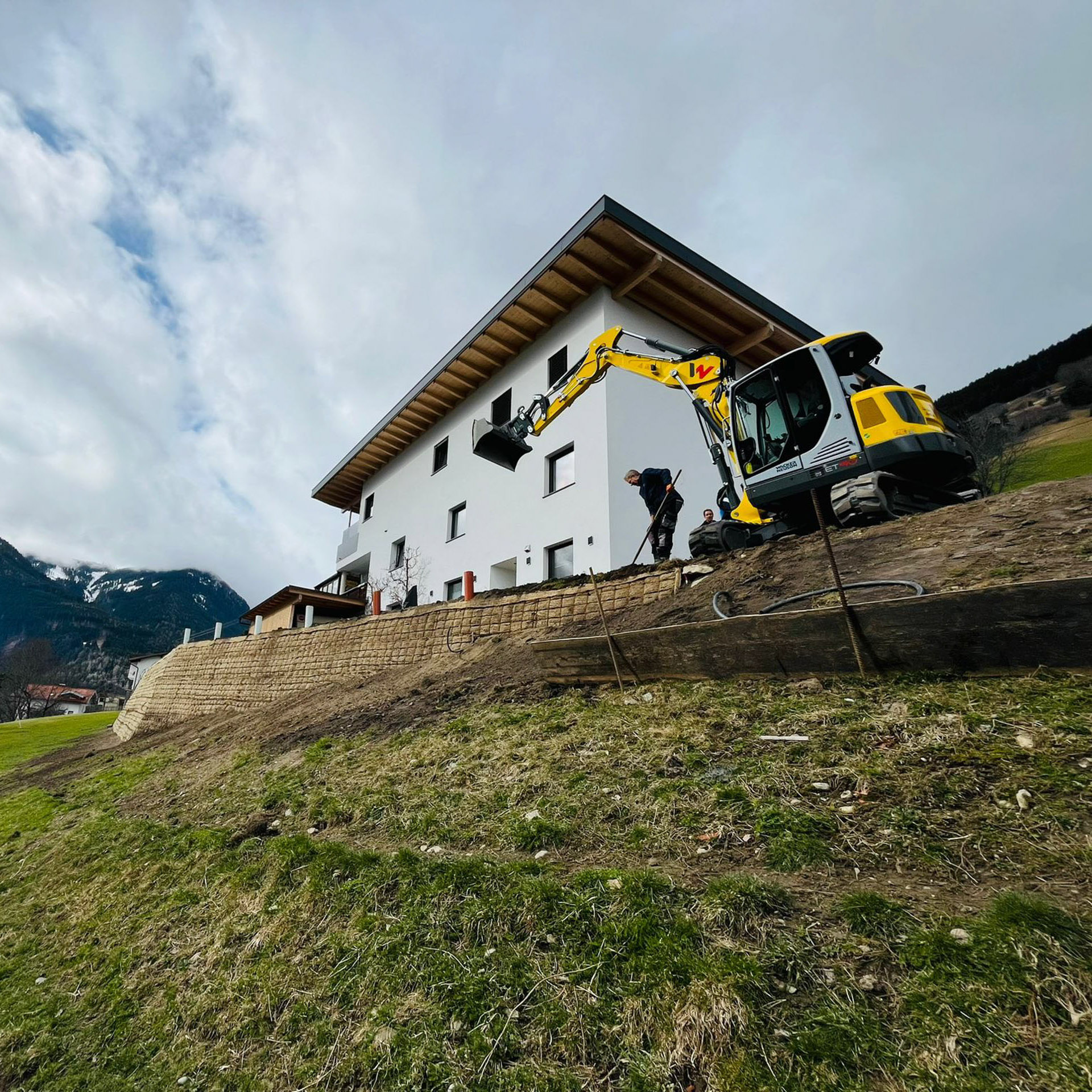 Kettenbagger im Einsatz bei bewehrter Erde, zwei Bauarbeiten schaufeln