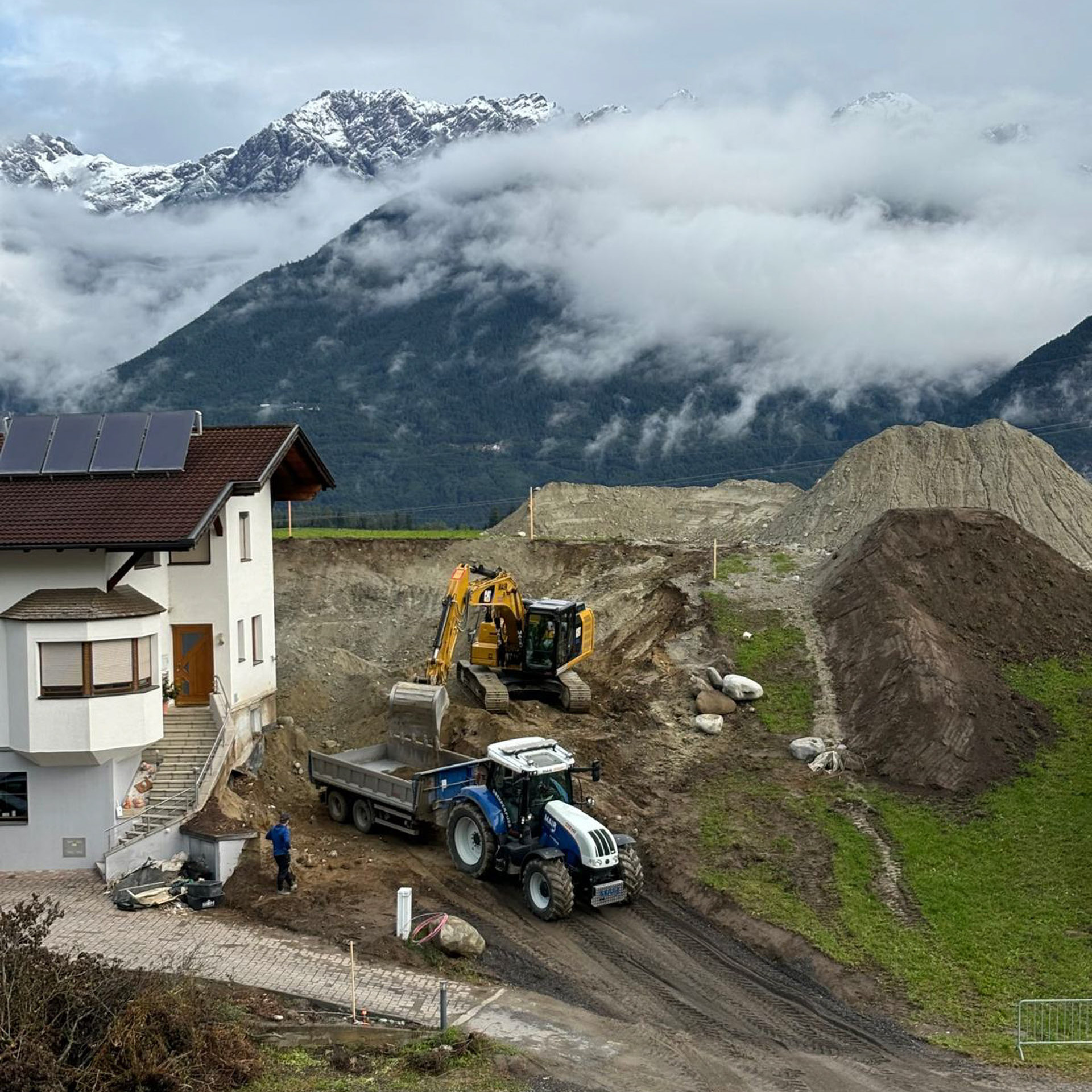 Kettenbagger und Traktor beim Grundaushub