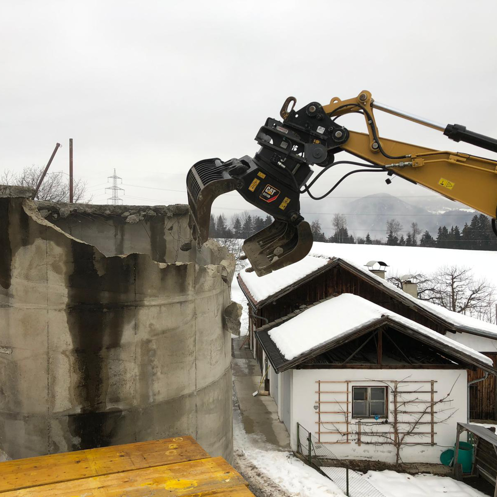 Kettenbagger bei Abbrucharbeiten eines Silos im Winter