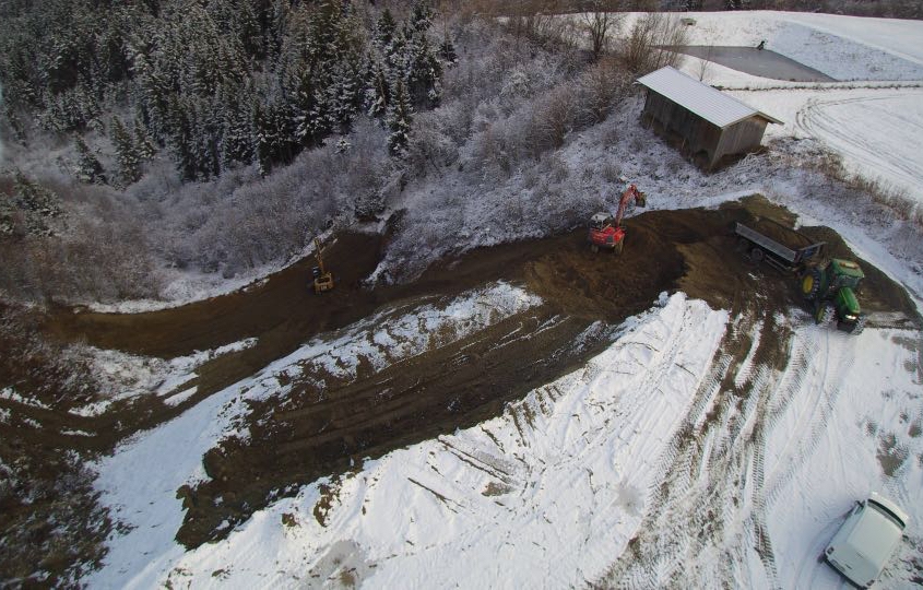 Kettenbagger und Traktor mit Anhänger im Einsatz bei Deponie in Oberperfuss