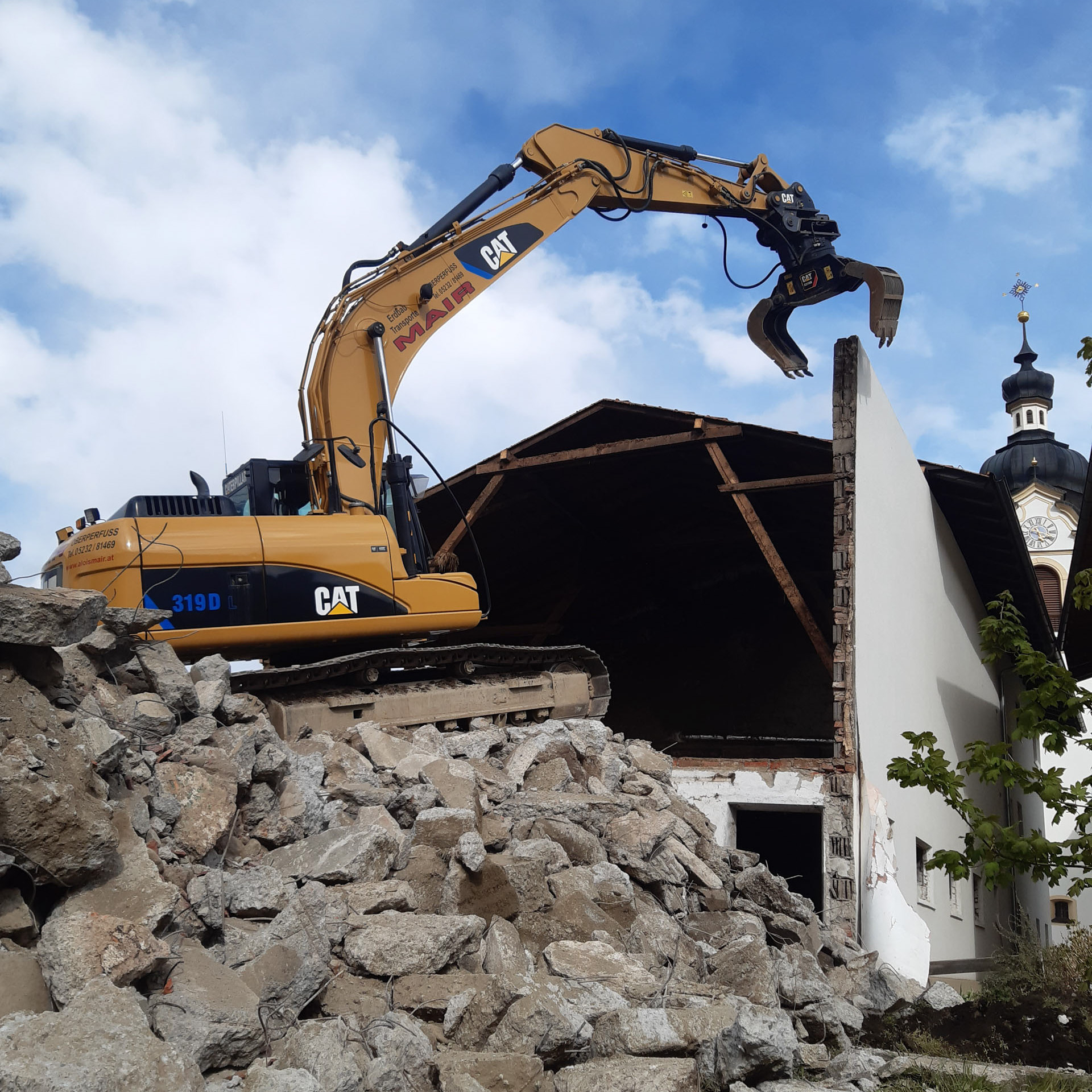 Kettenbagger bei Abbrucharbeiten eines Stalles