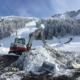 Kettenbagger beim Pisten- und Liftbau bei Schnee