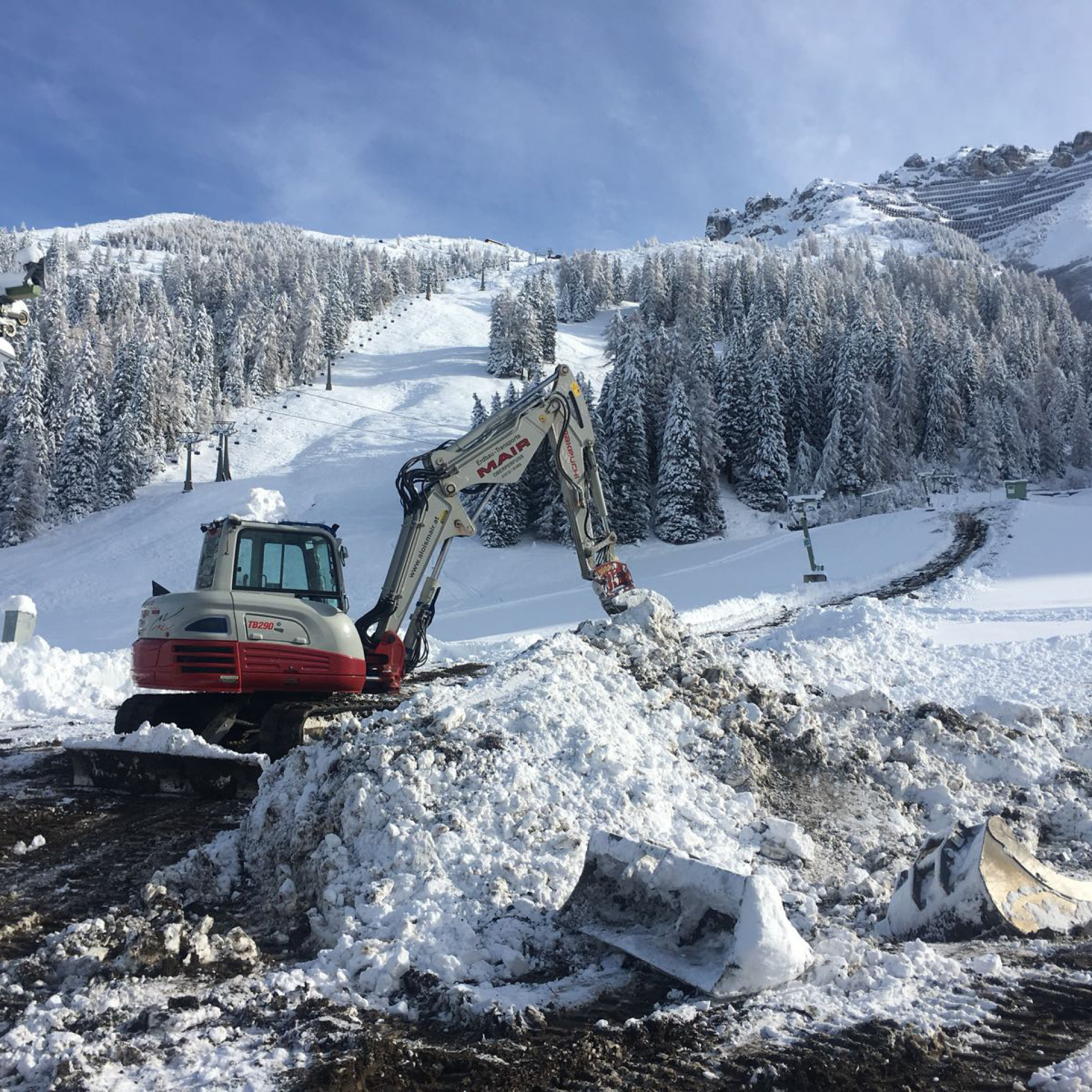 Kettenbagger beim Pisten- und Liftbau bei Schnee