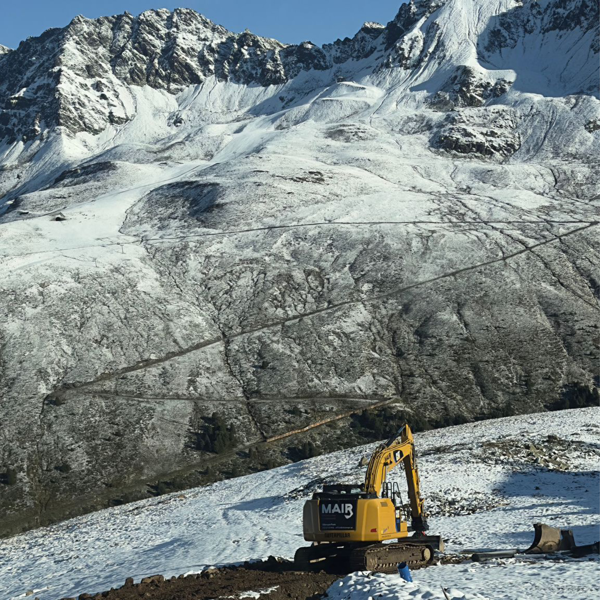 Kettenbagger beim Pisten- und Liftbau bei Schnee